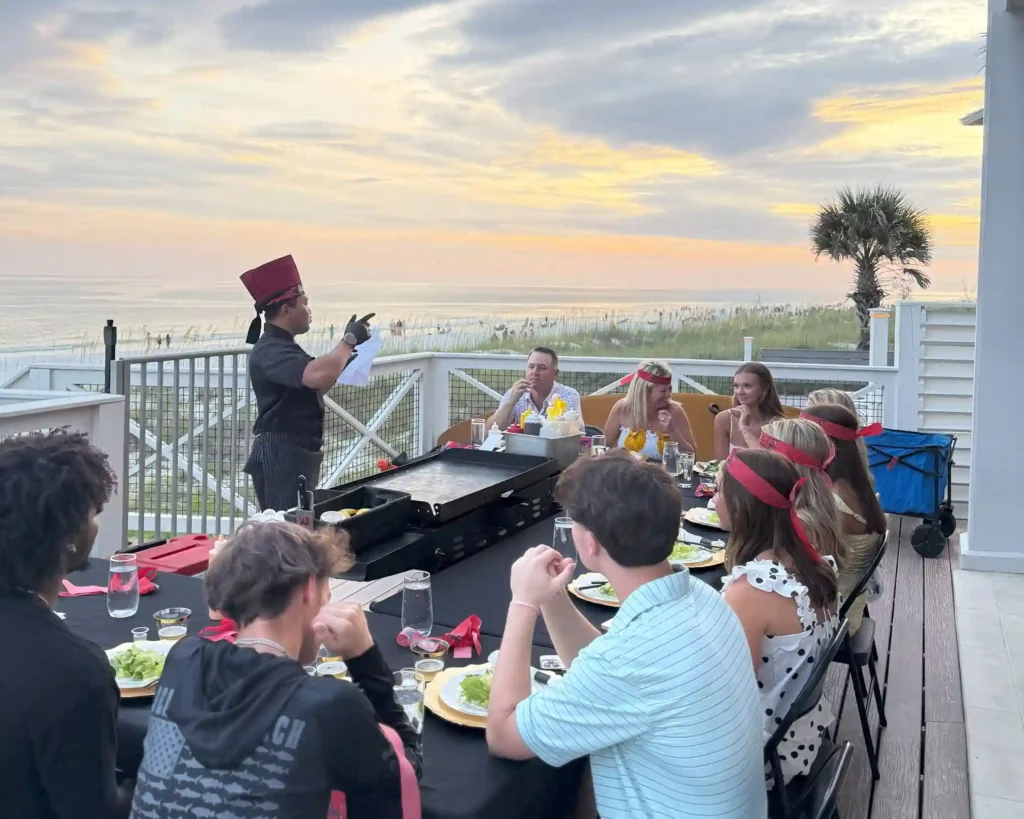 Private hibachi chef cooking for guests during sunset beachside event in Florida